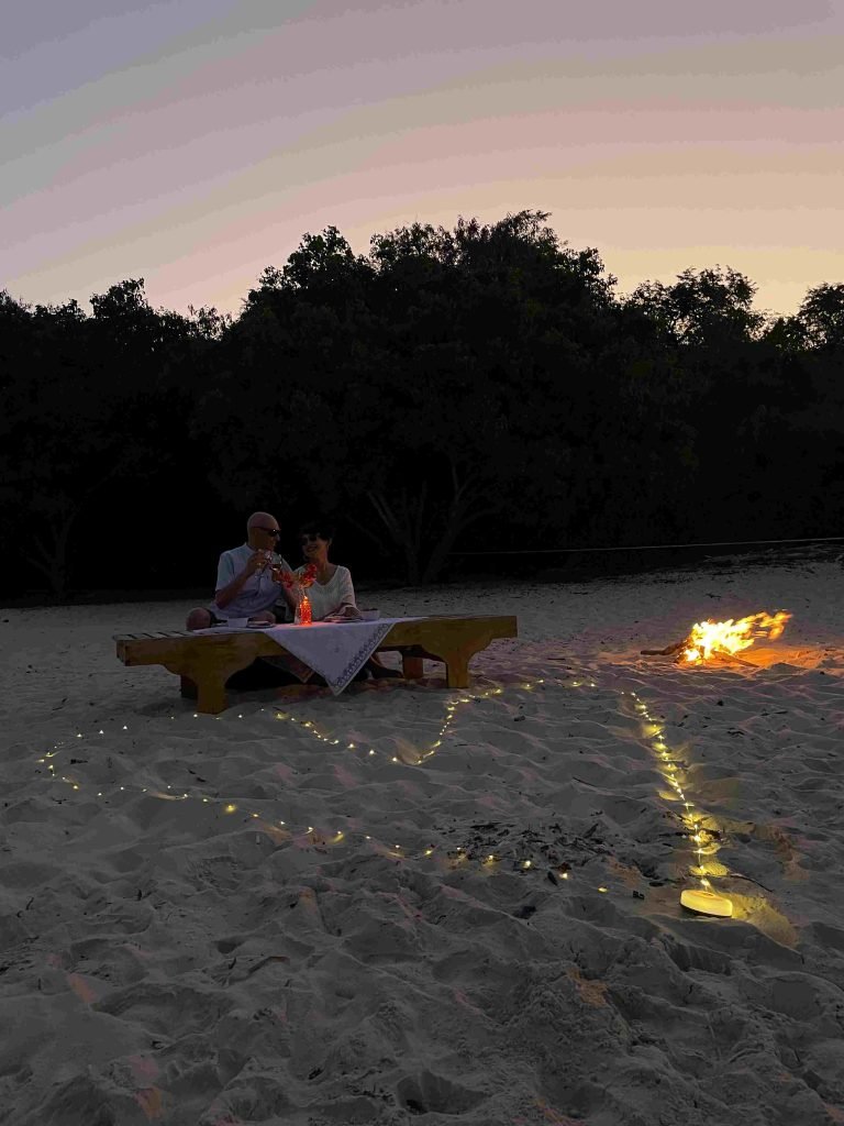 Bonfire dinner experience on a white sand beach in Labuan Bajo during sunset