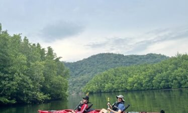 A serene, secluded beach at sunset with kayaks lined up on the shore, picturesque and peaceful.