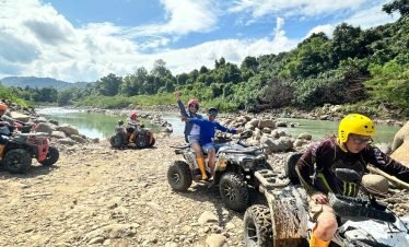 Adventurer riding an ATV through a jungle trail in Flores