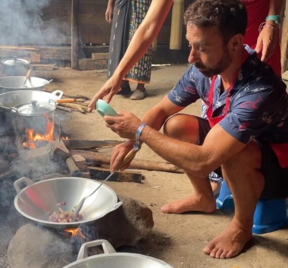 Ina's Cooking Class 4 A local woman demonstrating traditional village crafts, with villagers observing.
