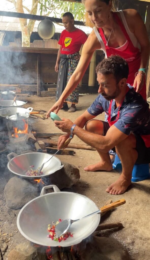 A local woman demonstrating traditional village crafts, with villagers observing.