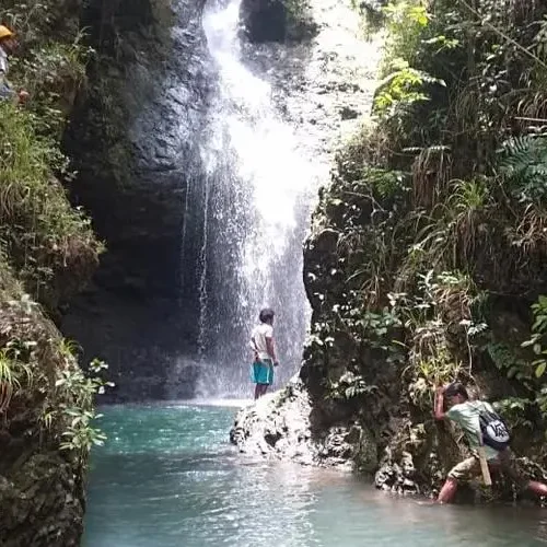 Trekkers exploring Cunca Lolos waterfall gorge in western Flores