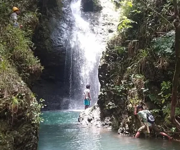 Trekkers exploring Cunca Lolos waterfall gorge in western Flores