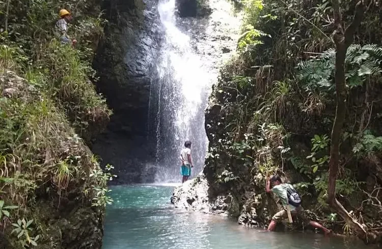 Trekkers exploring Cunca Lolos waterfall gorge in western Flores