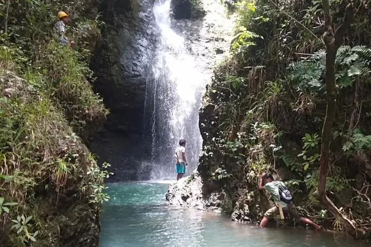 Trekkers exploring Cunca Lolos waterfall gorge in western Flores