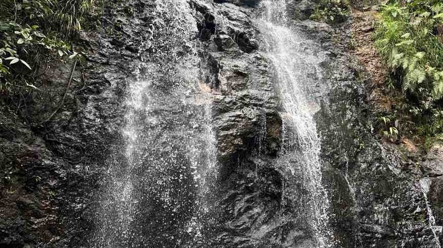 Waterfalls & Sunset Serenity: Cunca Plias, Cunca Wulang & Desa Wisata Melo - A Flores Inland Adventure 2 A scenic view of cascading waterfalls with lush greenery and a person swimming in the pool below. Desa Wisata Melo Tour