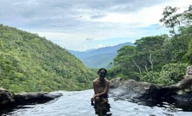 A clear, turquoise natural pool surrounded by lush green foliage in Flores.