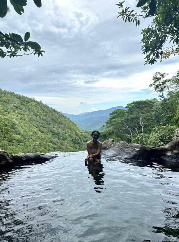 A clear, turquoise natural pool surrounded by lush green foliage in Flores.