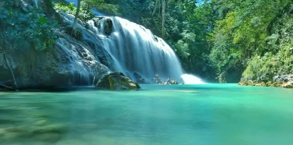 Cunca Plias waterfall cascading into a turquoise pool in Flores, Indonesia