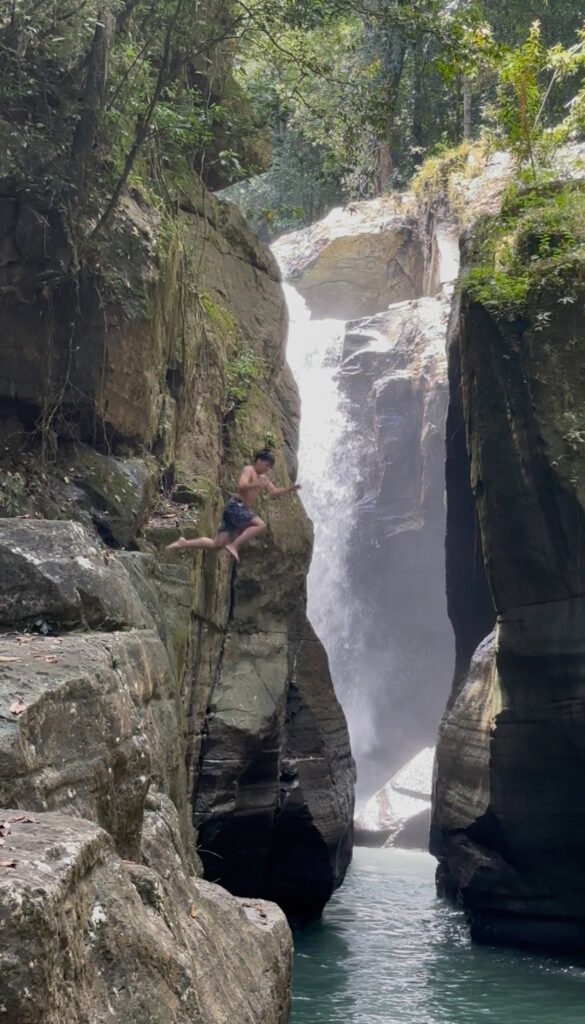 People swimming and relaxing in the clear, tranquil pools of Cunca Wulang Waterfall.