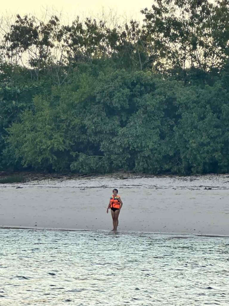 A person fishing on a quiet, scenic island with turquoise water and lush greenery in the background.Snorkeling Tour in Labuan Bajo