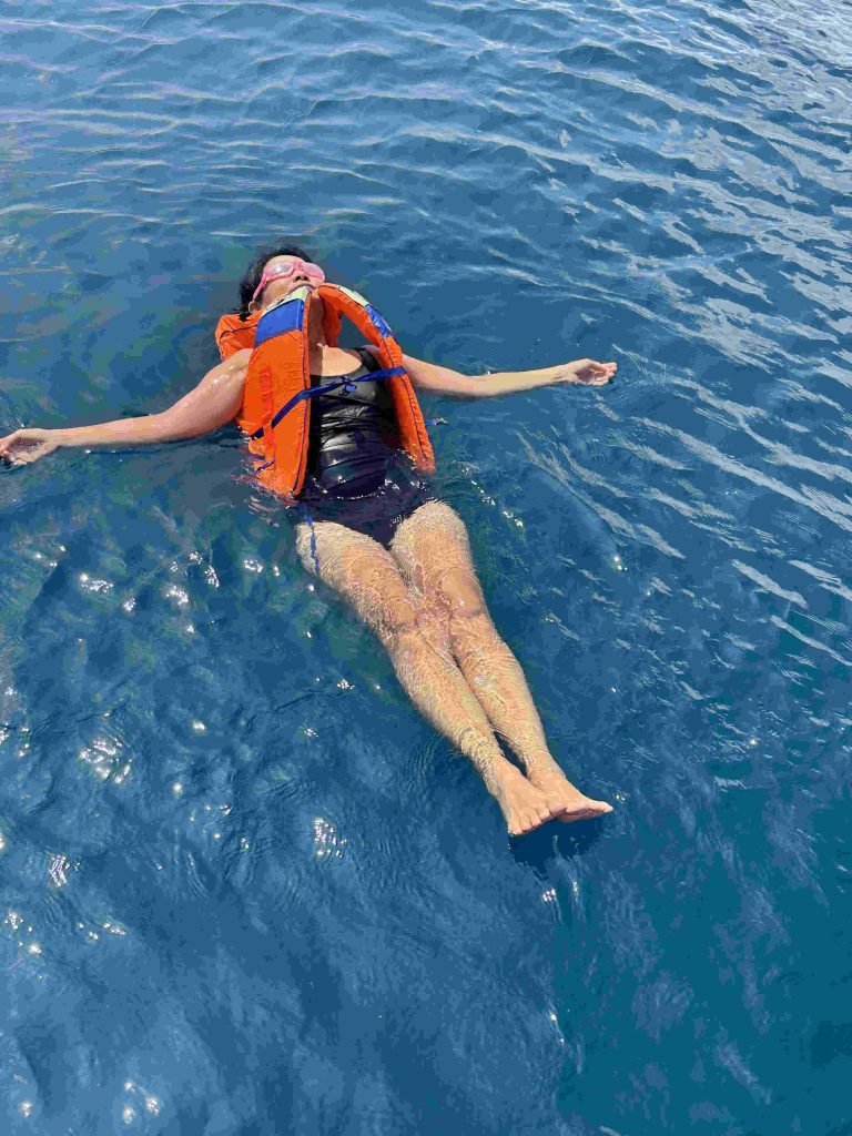 Snorkeler exploring vibrant coral reef in crystal-clear waters of Labuan Bajo,Labuan Bajo snorkeling trip