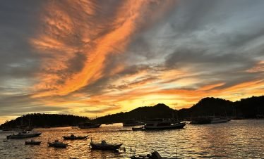 Sunset over Labuan Bajo harbor with fishing boats and calm ocean,Labuan Bajo snorkeling trip