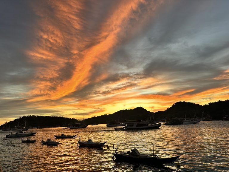 Sunset over Labuan Bajo harbor with fishing boats and calm ocean,Labuan Bajo snorkeling trip