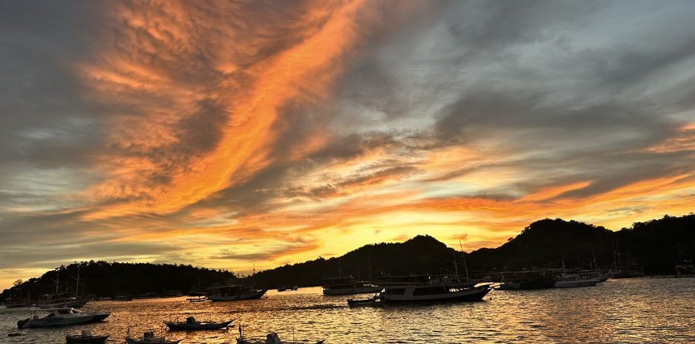 Sunset over Labuan Bajo harbor with fishing boats and calm ocean,Labuan Bajo snorkeling trip