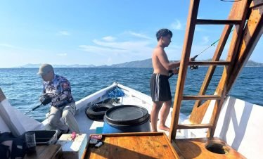 Traveler relaxing on a traditional boat in calm sea near Labuan Bajo