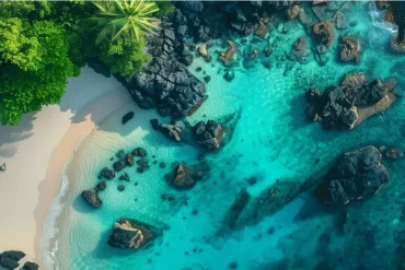 Blog 1 Aerial view of a pristine tropical beach near Labuan Bajo with turquoise waters and lush greenery