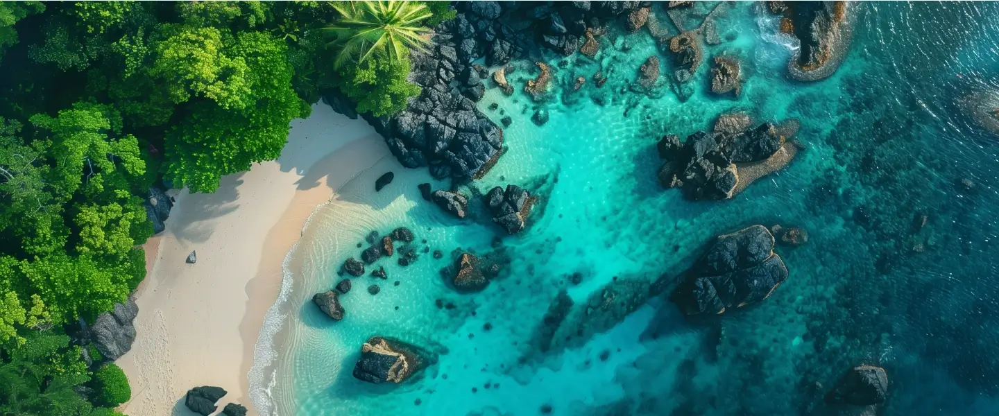 Aerial view of a pristine tropical beach near Labuan Bajo with turquoise waters and lush greenery
