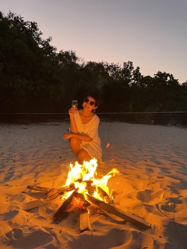 Beyond Bali: Authentic Travel Experiences in East Indonesia 4 A cozy dinner setup on the sand with a bonfire flickering nearby at Wae Ri I Beach.