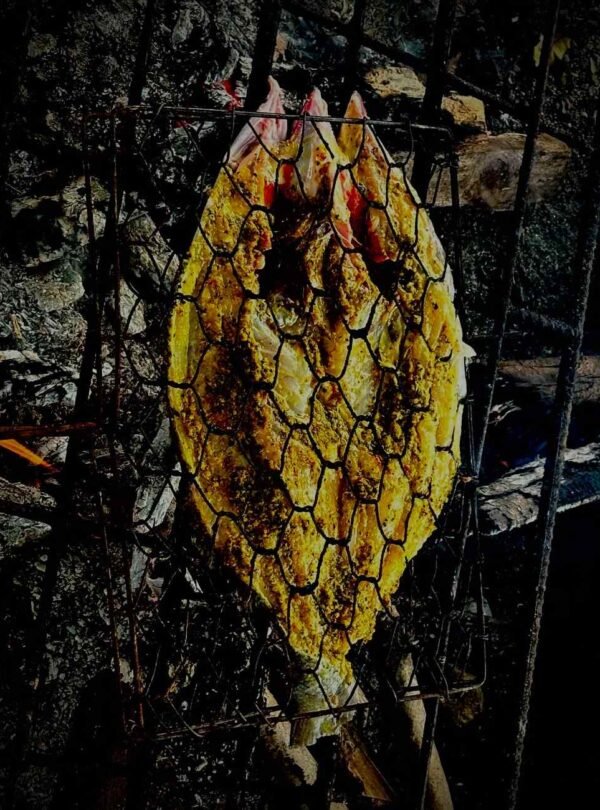 Freshly grilled fish on a beachside fire in Rangko Village