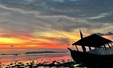 Traditional boat at sunset on Rangko beach, West Flores