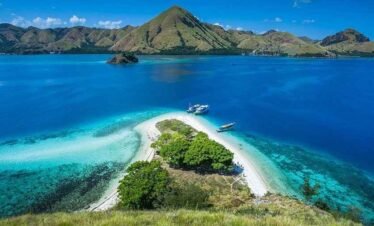 Boat anchored near small tropical island with turquoise water near Labuan Bajo