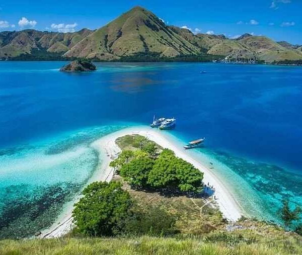 Boat anchored near small tropical island with turquoise water near Labuan Bajo