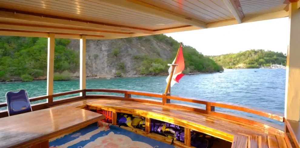 Luxury liveaboard cabin interior with ocean view and tropical island mountains in Komodo