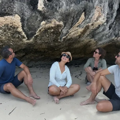 Travelers exploring a coastal rock cave during a Labuan Bajo island tour