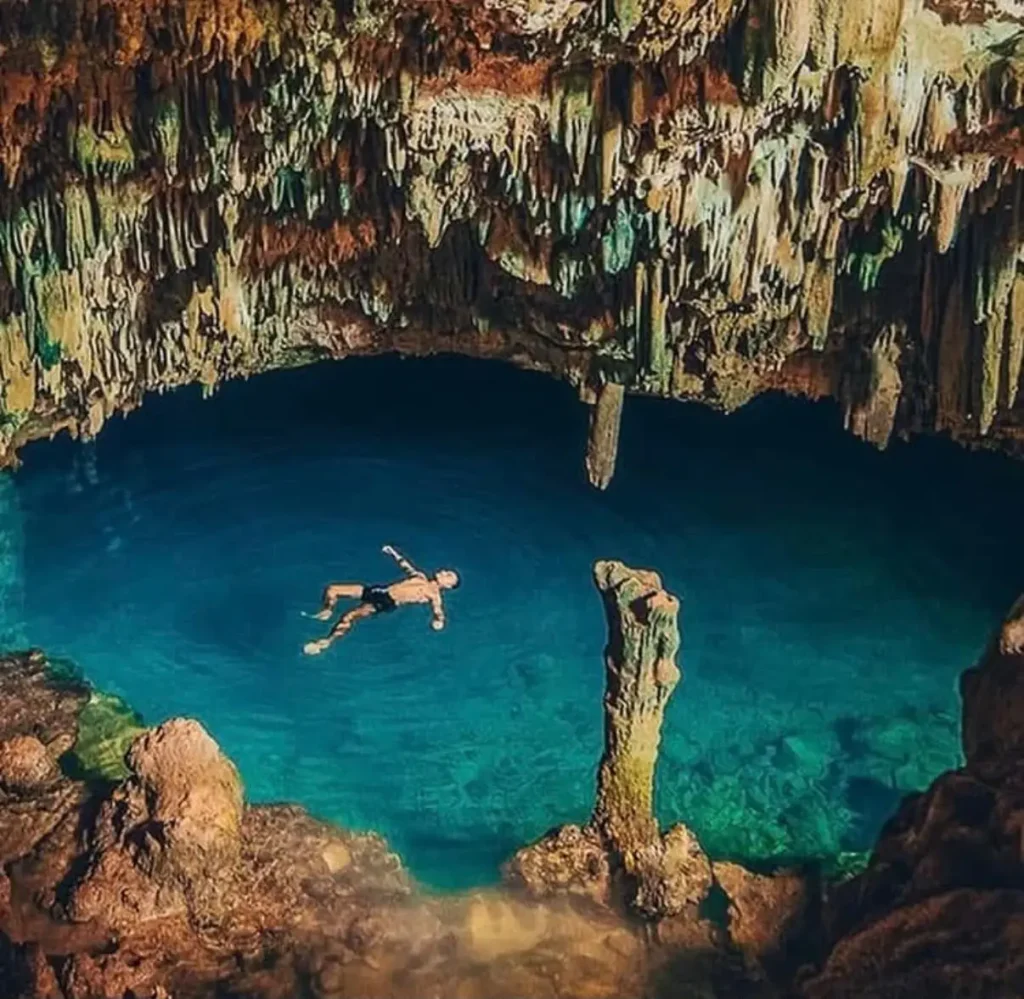 Traveler swimming in the natural saltwater pool inside Rangko Cave near Labuan Bajo