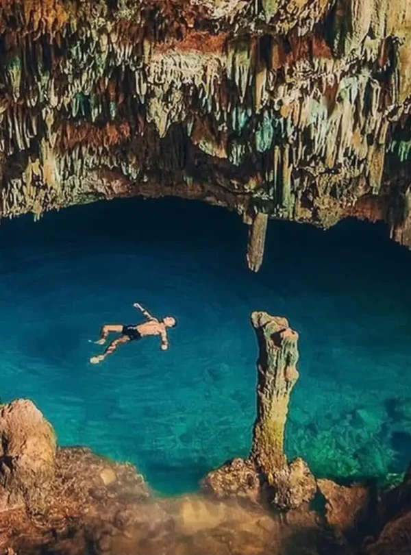 Traveler swimming in the natural saltwater pool inside Rangko Cave near Labuan Bajo
